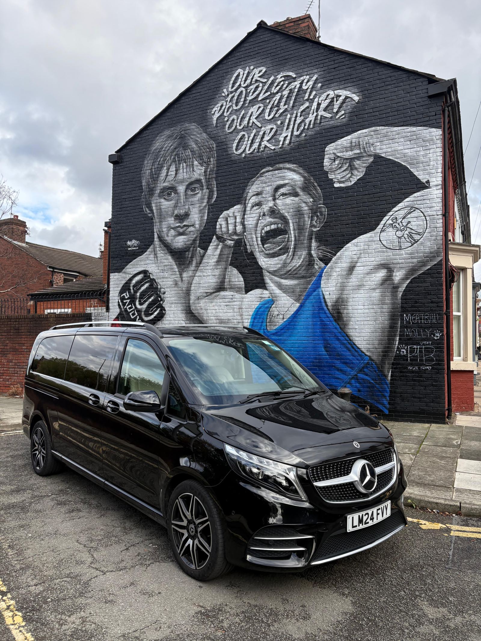 AO Platinum Chauffeurs V-Class beside a Liverpool FC mural near Anfield
